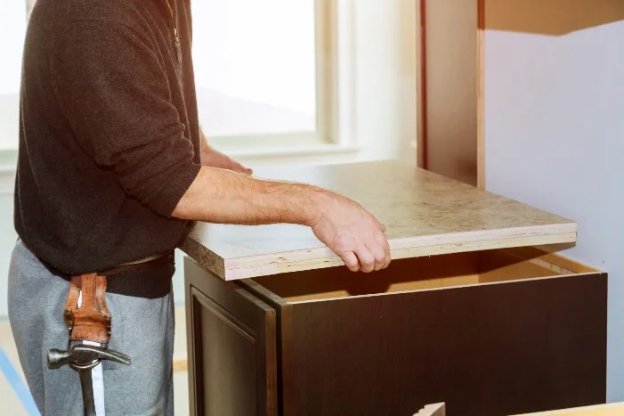 Person baut Küchenarbeitsplatte ein