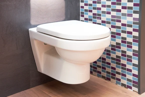 Hängende Toilette an gefliester Wand