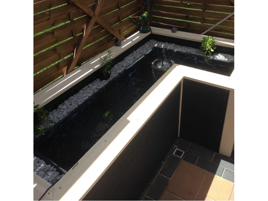 L-förmiger Gartenteich mit Springbrunnen