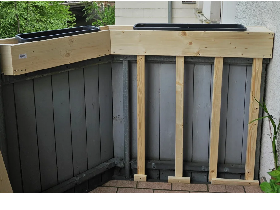 Zwei Blumenkästen auf einem Holzgestell