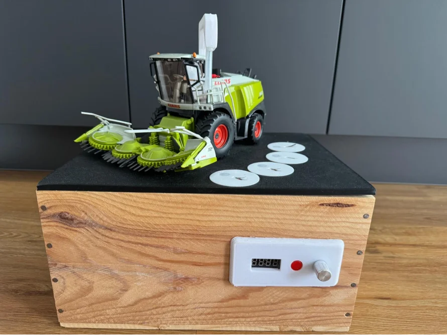Modell eines Mähdreschers auf einer Holzkiste