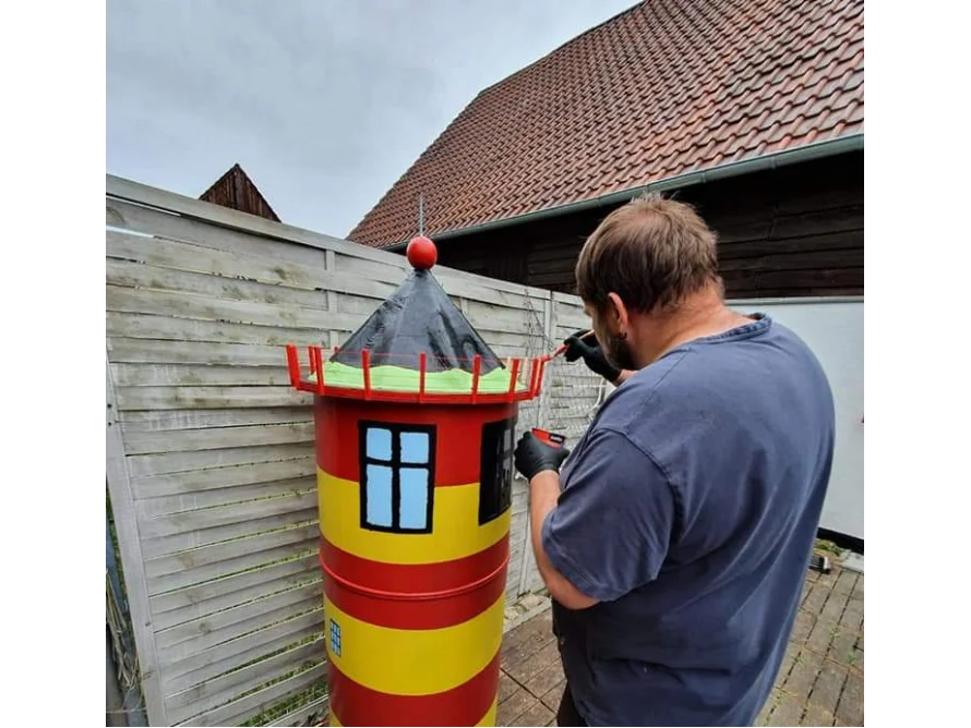 Person bemalt Leuchtturmmodell