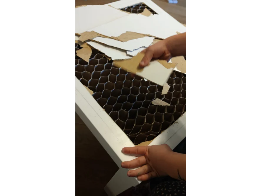 Kind zerreißt Pappe