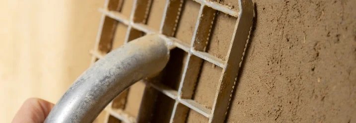 Hand verwendet Reibe auf Lehmboden