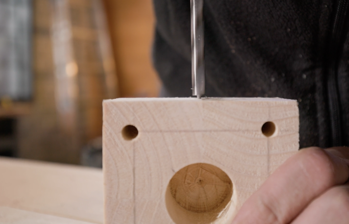 Person meißelt Holz