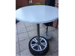 Runder weißer Tisch auf einem Autoreifen