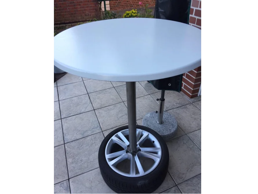 Runder weißer Tisch auf einem Autoreifen