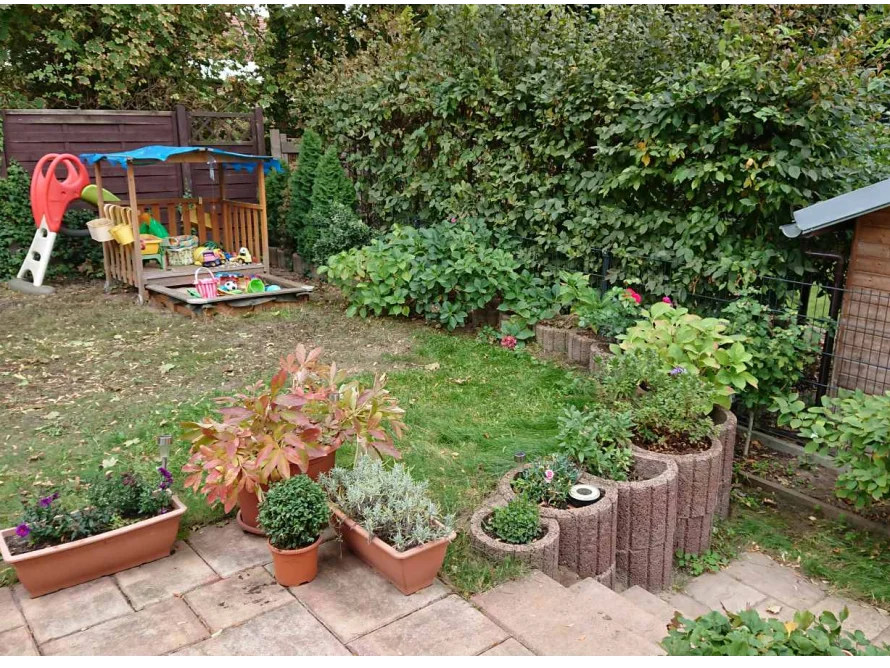 Garten mit Spielhaus und Blumen