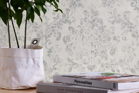 Verzierte graue Tapete mit Pflanzen daneben