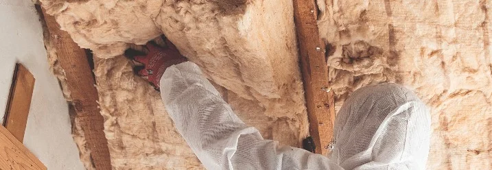 Person dämmt Dachboden