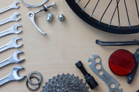 Diverses Fahrradwerkzeug und verschiedene Ersatzteile auf einem Tisch.