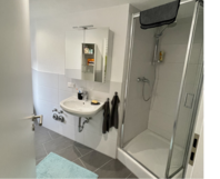Modernes Badezimmer mit Dusche und Waschbecken.