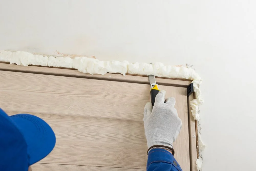 Entfernen von unnötigem getrocknetem Befestigungsschaum aus dem Türschlitz.