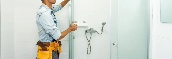 Person montiert Duschkabine