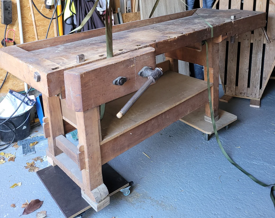 Eine alte Hobelbank aus Holz steht in einer Werkstatt.