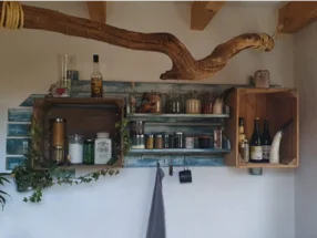 Rustikales Regal mit Gewürzen und Flaschen