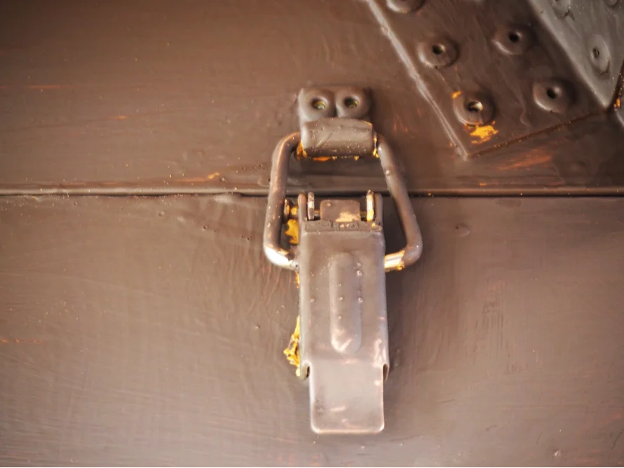 Metallverschluss an brauner Holzkiste