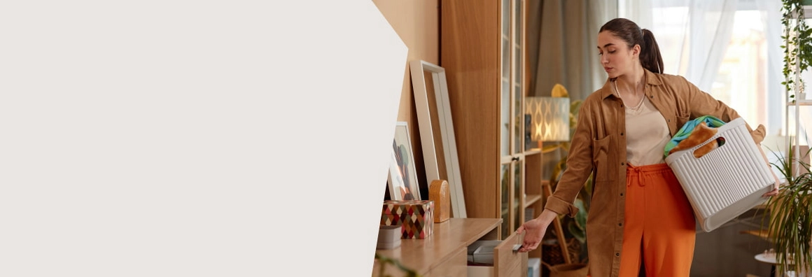 Frau hat Korb unterm Arm und greift nach offener Schublade