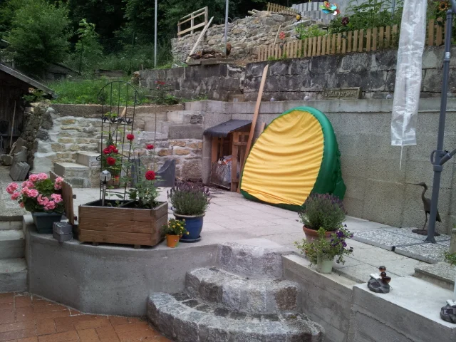 Steinterrasse mit Blumen und einem Schlauchboot