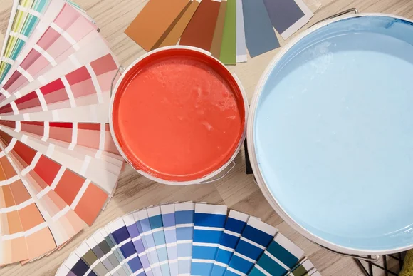 Farbtöpfe und Farbpaletten auf Holztisch