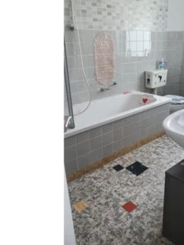 Badewanne mit grauen Fliesen