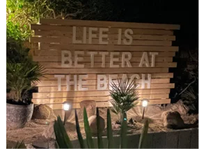 Holzschild mit der Aufschrift "Life is better at the beach".