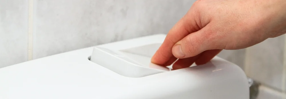 Hand drückt Spülkastentaste