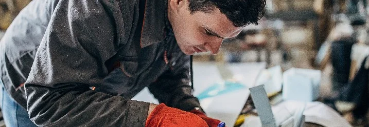 Person zeichnet auf Metall