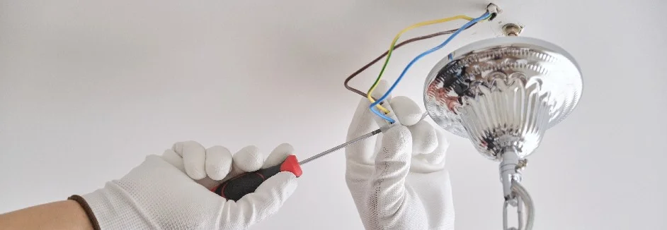 Person schließt Lampe mit Schraubendreher an