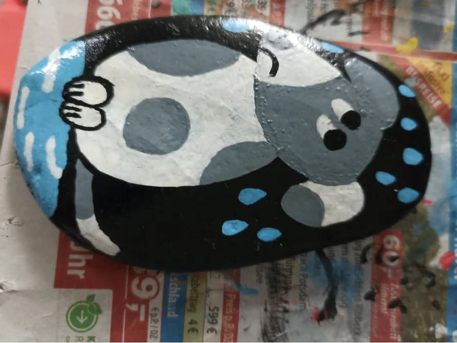 Bemalter Stein mit einem traurigen Hund im Regen