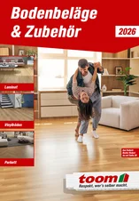 Zwei Personen tanzen ausgelassen auf einem Holzboden in einem Wohnzimmer.