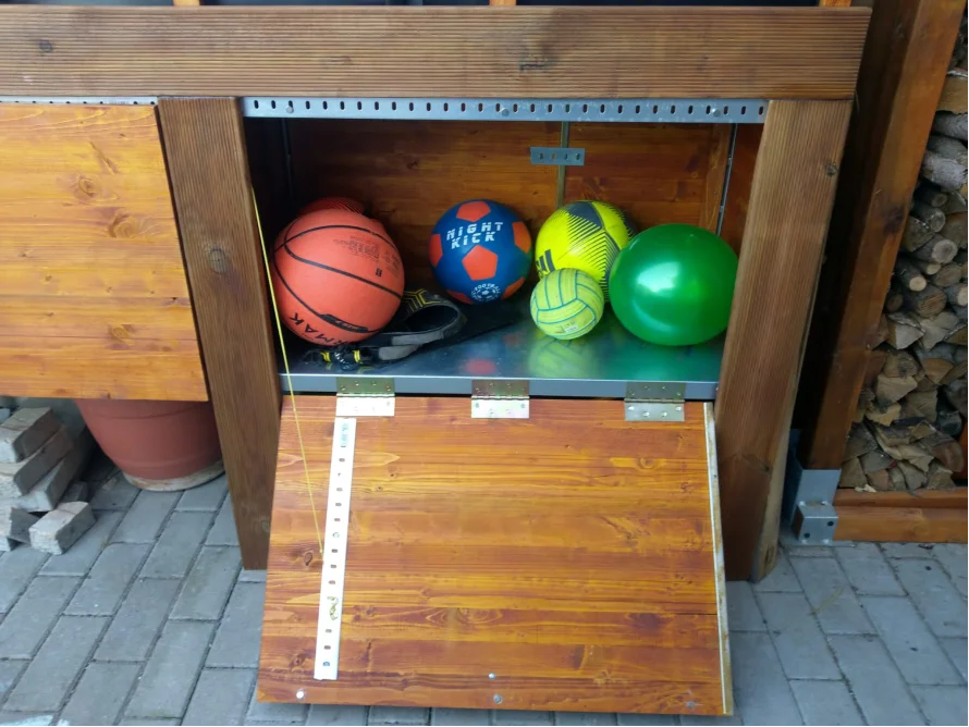 Offener Holzschrank mit Bällen