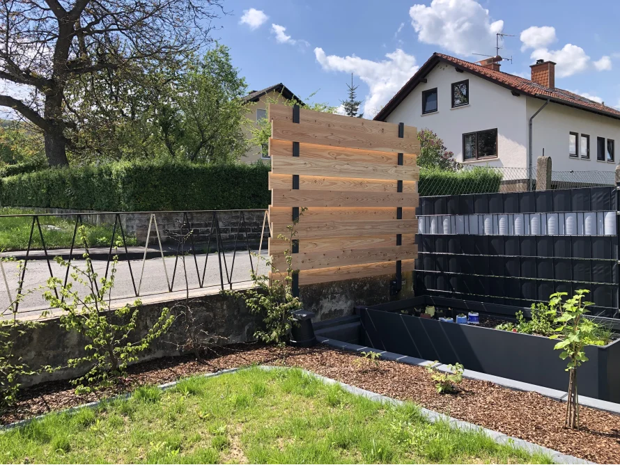 Garten mit Holzwand und Hochbeet