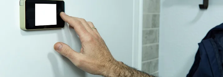 Hand bedient ein Wanddisplay.