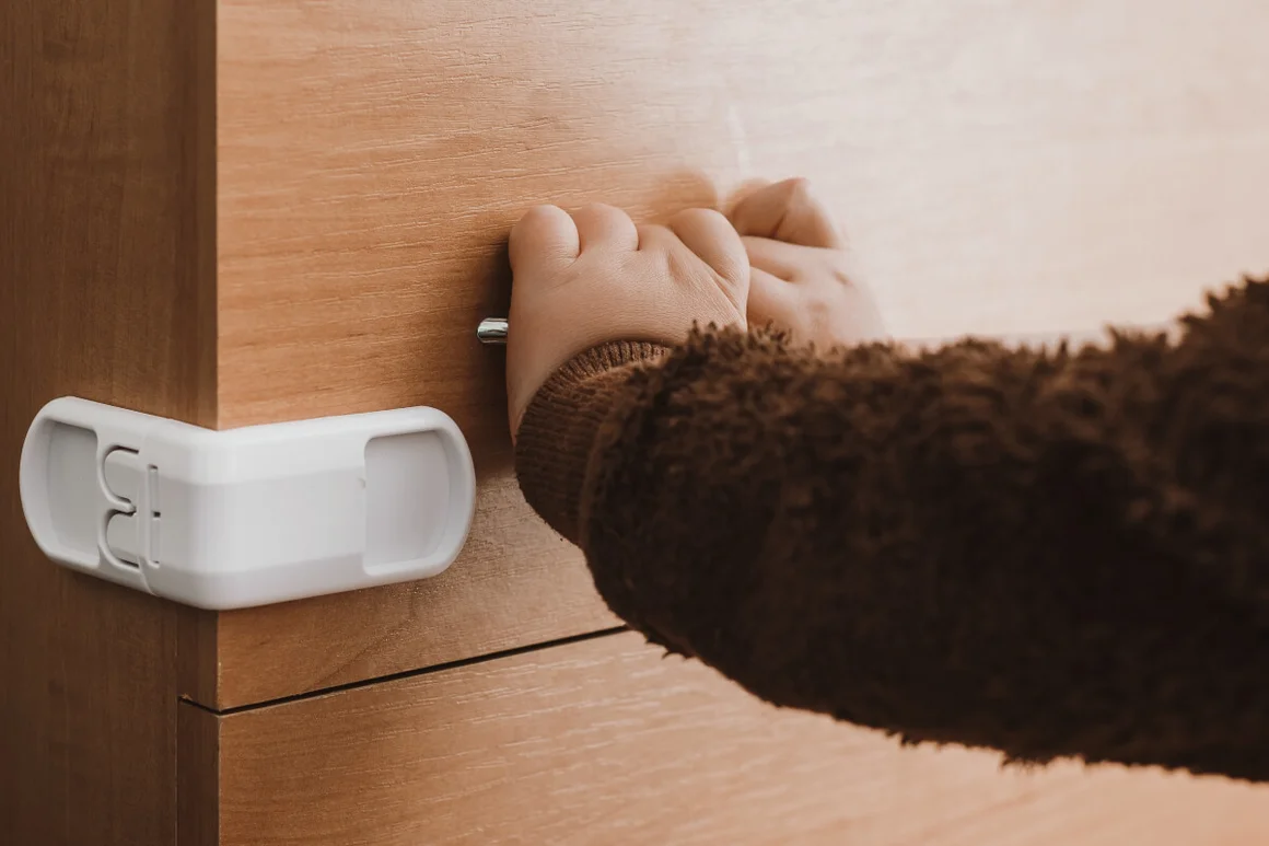 Kind öffnet Schranksicherung