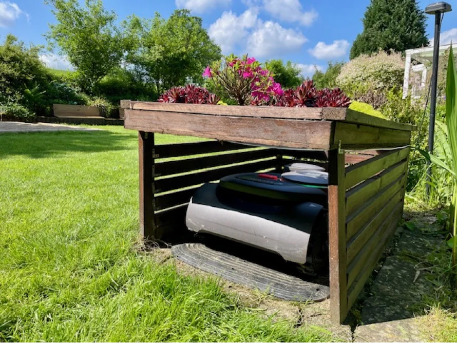 Roboter-Rasenmäher unter einem Schutzdach