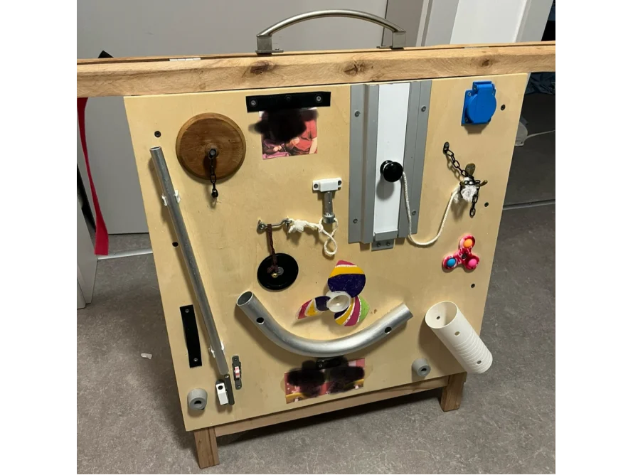 Ein Busyboard aus Holz mit verschiedenen Elementen.