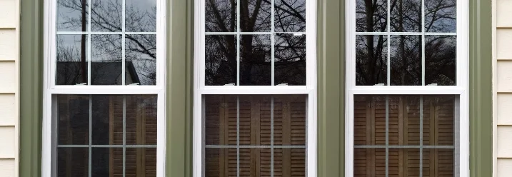 Drei weiße Fenster mit grünen Rahmen