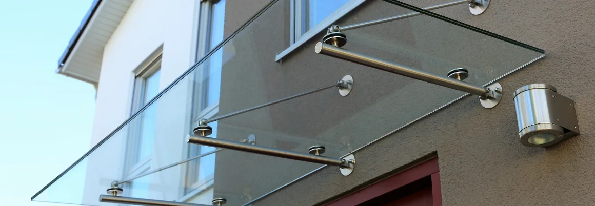 Ein gläsernes Vordach über einer Tür.