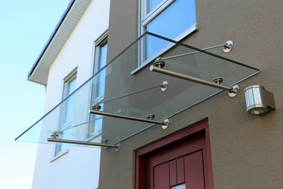Ein gläsernes Vordach über einer Tür.
