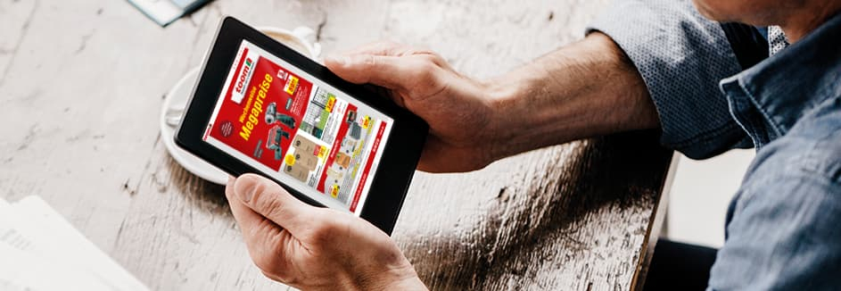 Eine Person blättert auf einem Tablet in einem digitalen Prospekt eines Baumarktes.