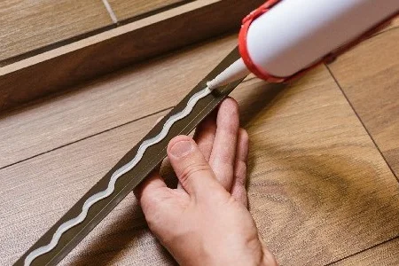 Person trägt Klebstoff auf