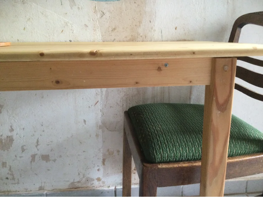 Holztisch mit grünem Stuhl