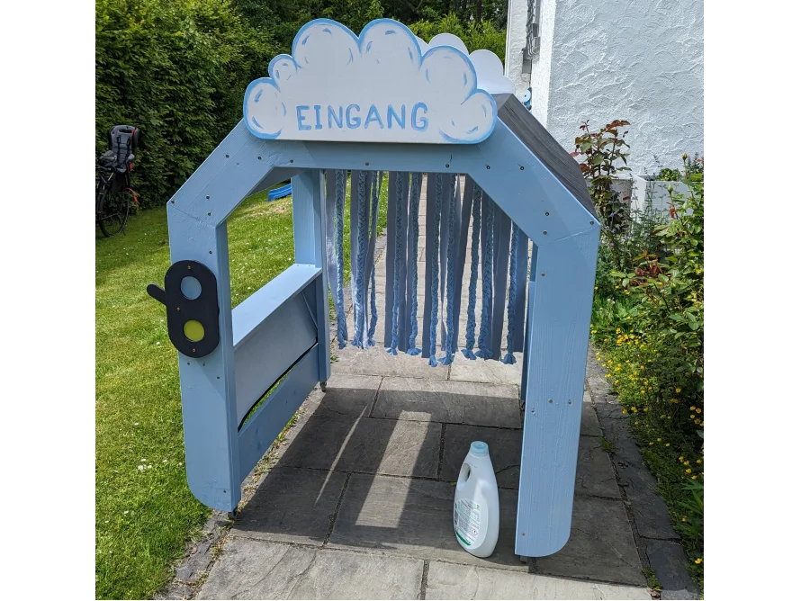 Blaues Spielhaus mit Stoffstreifen