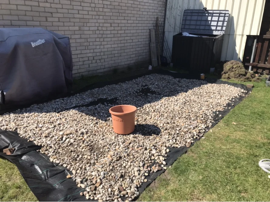 Kies wird auf einer Rasenfläche verteilt