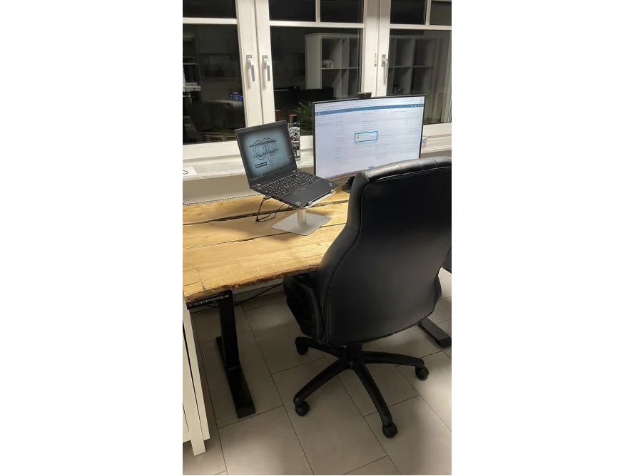 Stehtisch mit Laptop und Bürostuhl