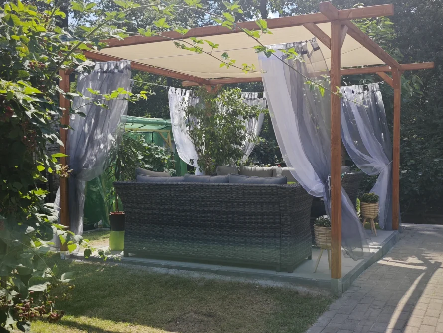 Überdachte Sitzecke mit Lounge Möbeln im Garten