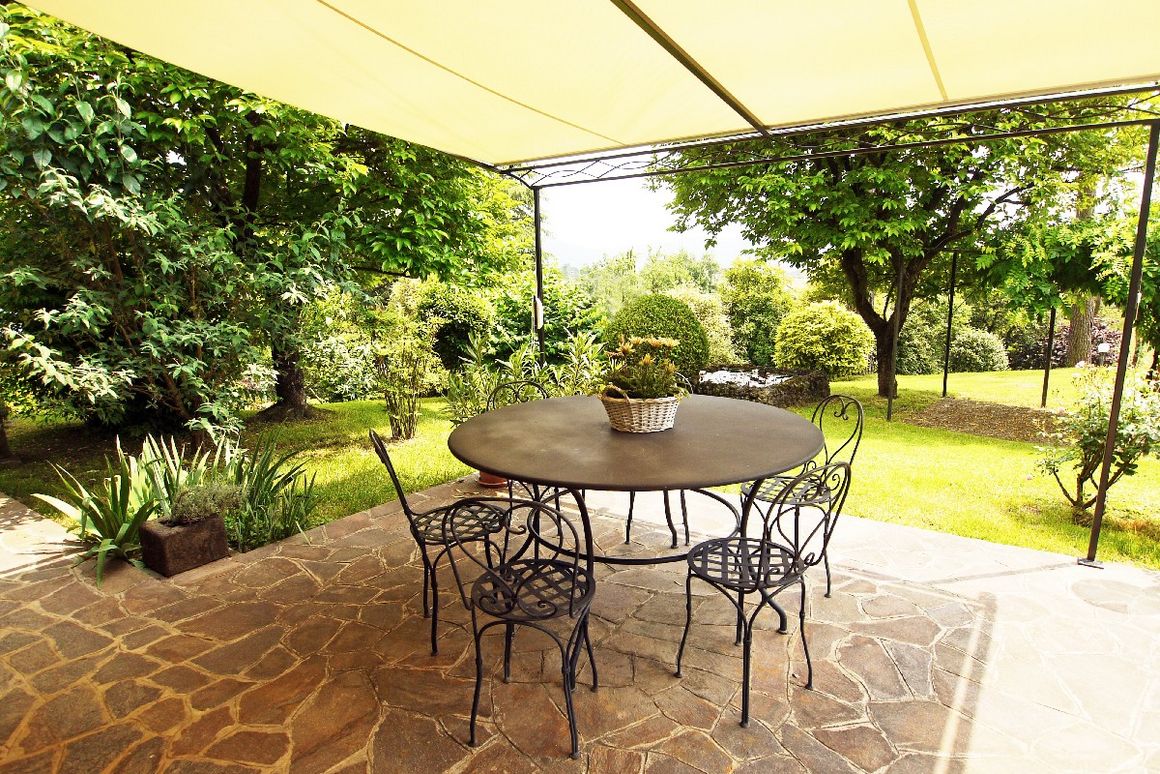 Sonnensegel über Terrasse mit Stühlen und Tisch