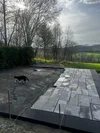 Eine schwarz-weiße Katze läuft über eine im Bau befindliche Terrasse.
