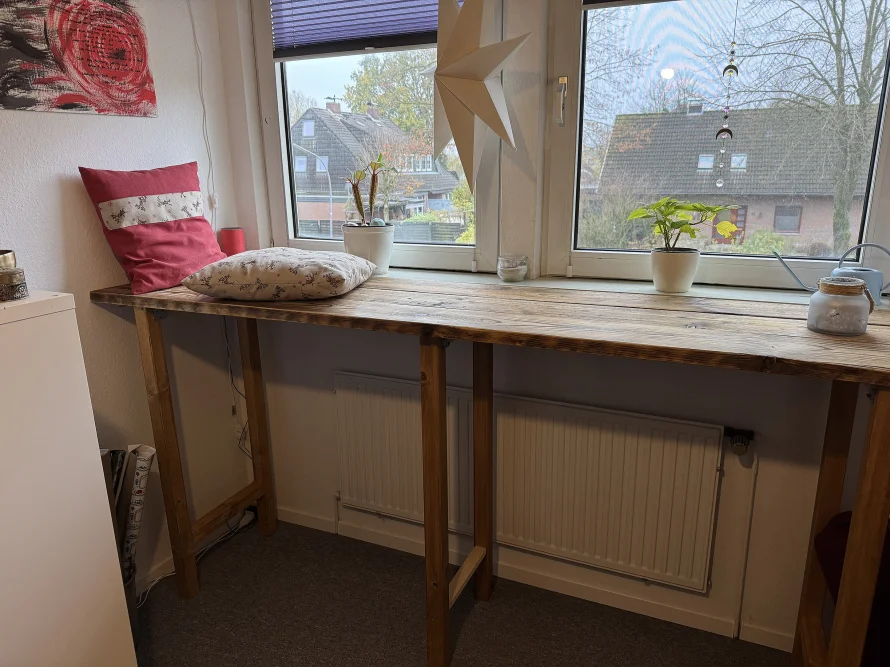 Hoher Tisch aus Holz an Fensterfront